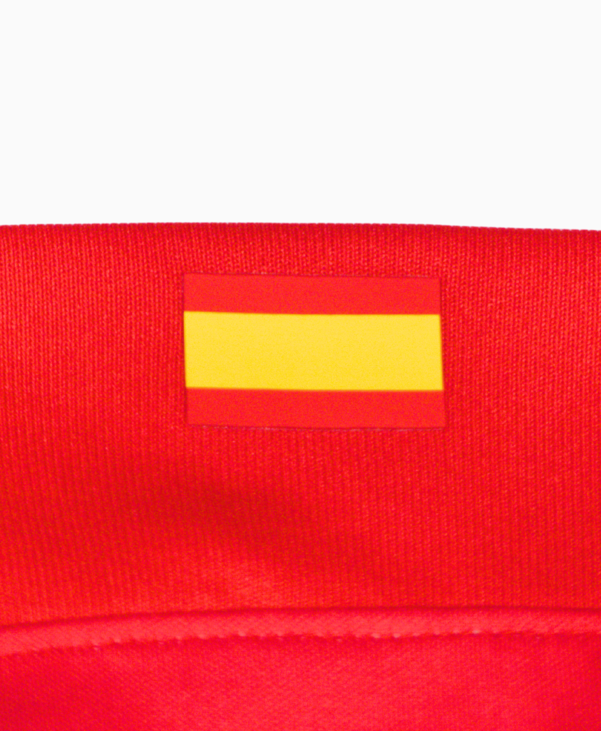 Imagen del detalle de la bandera de España en el cuello de la camiseta de local del Atlético de Madrid de la temporada 2023-2024.