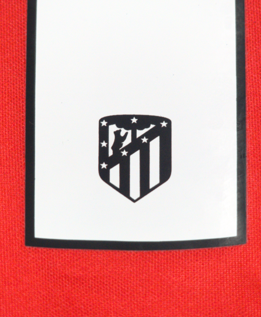 Imagen del detalle del escudo del Atlético de Madrid en el número del jugador de la camiseta de local de la temporada 2023-2024.