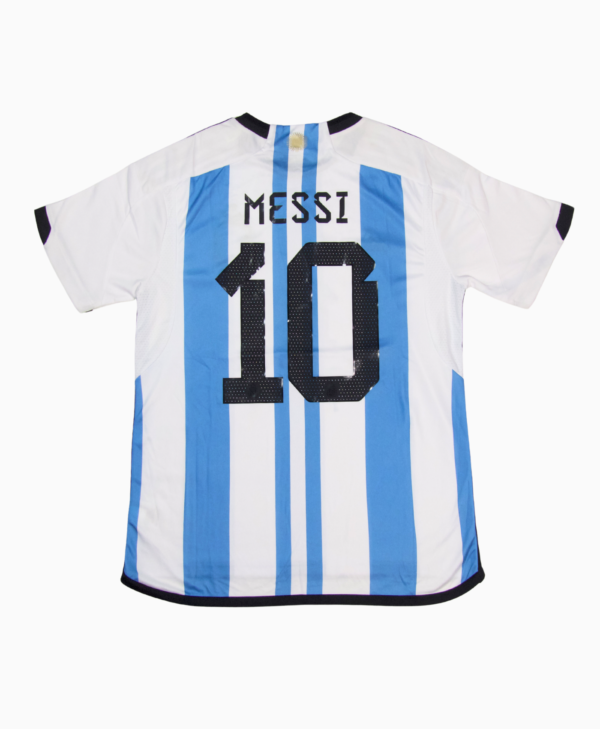 Imagen de la camiseta local de la selección argentina para la temporada 2023-2024, vista trasera, con el jugador Lionel Messi.