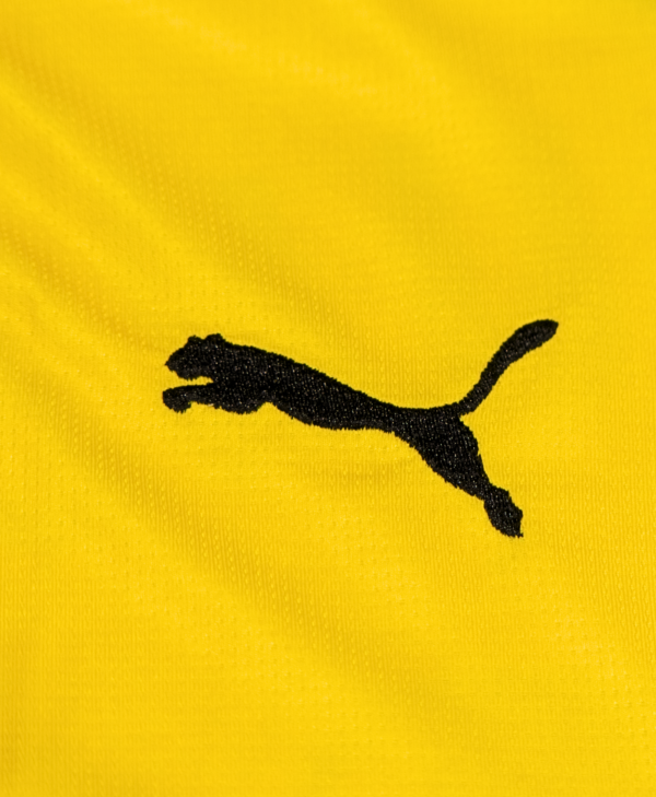 Imagen de un zoom del detalle del icono de PUMA, de la camiseta local del Borussia Dortmund para la temporada 2023-2024.