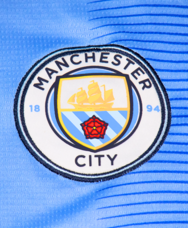 Imagen del escudo del Manchester City en la camiseta local para la temporada 2023-2024.