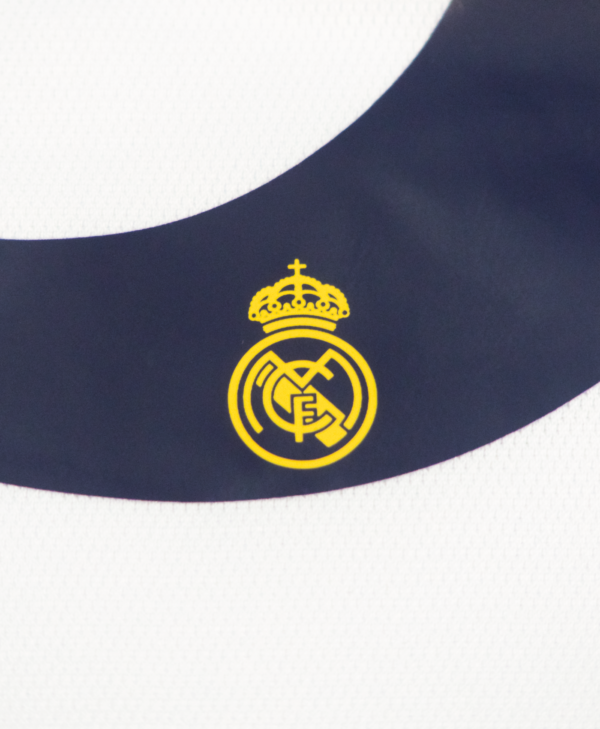 Imagen de un zoom en el detalle del escudo del Real Madrid en el número de la camiseta local del Real Madrid para la temporada 2023-2024.