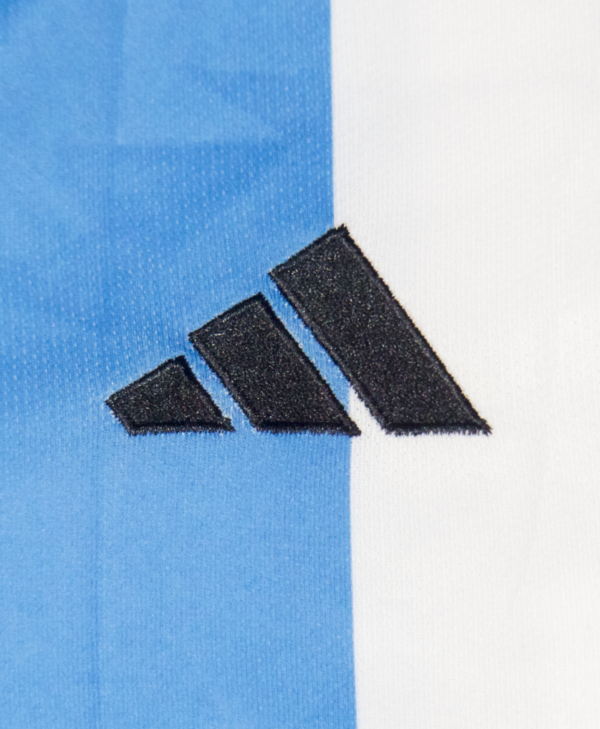 Imagen de un zoom en el icono de Adidas en la camiseta local de la selección argentina para la temporada 2023-2024.